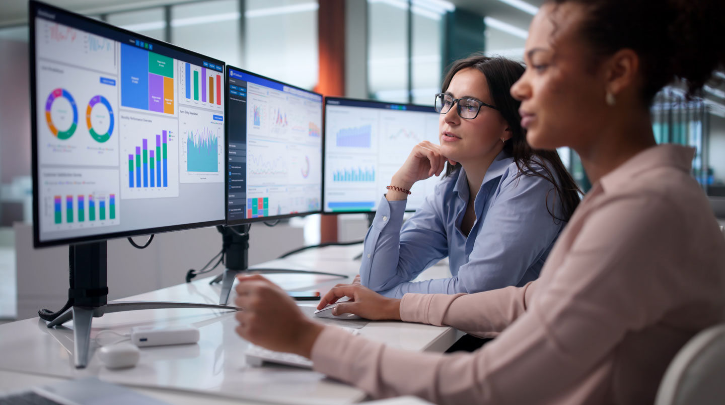 Gros plan sur écran affichant un tableau de bord opérationnel avec KPIs de performance d'interventions (temps moyen, taux SLA), main pointant des métriques spécifiques
